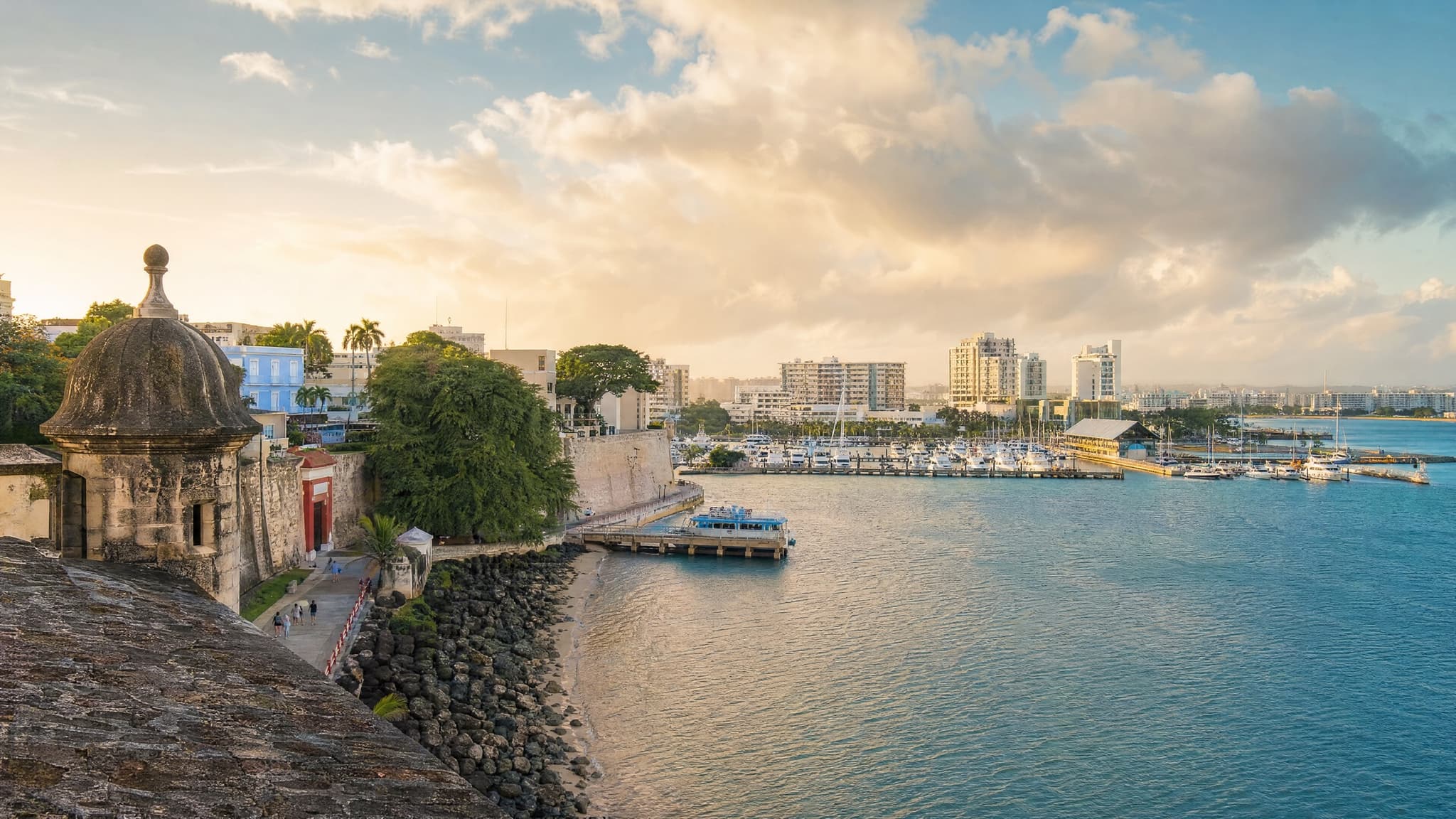 Colorful colonial rooftops in Old San Juan, Puerto Rico, with the Caribbean Sea beyond the city walls