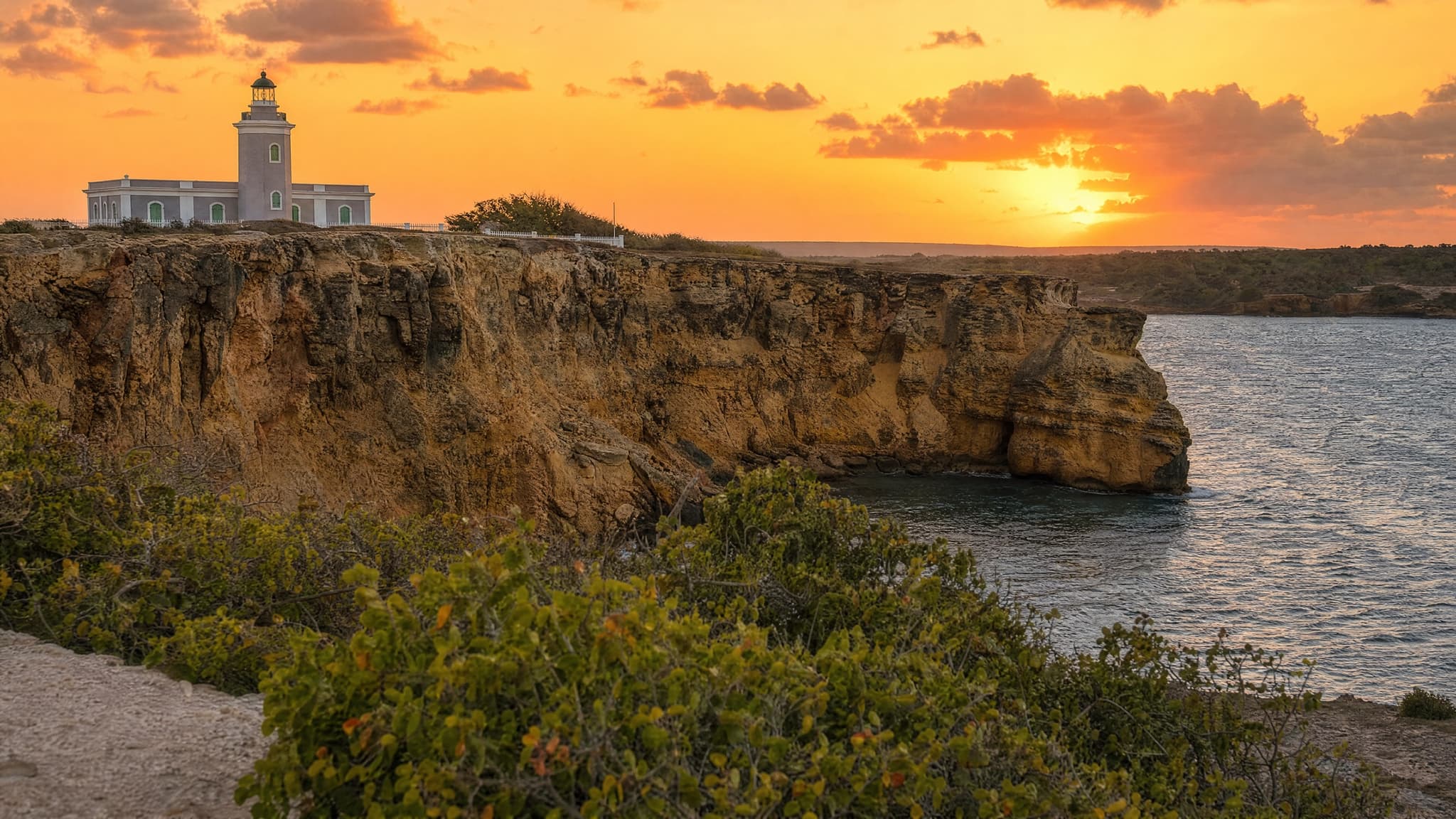 Limestone cliffs and the Los Morrillos lighthouse above Playa Sucia on the Cabo Rojo peninsula at sunset