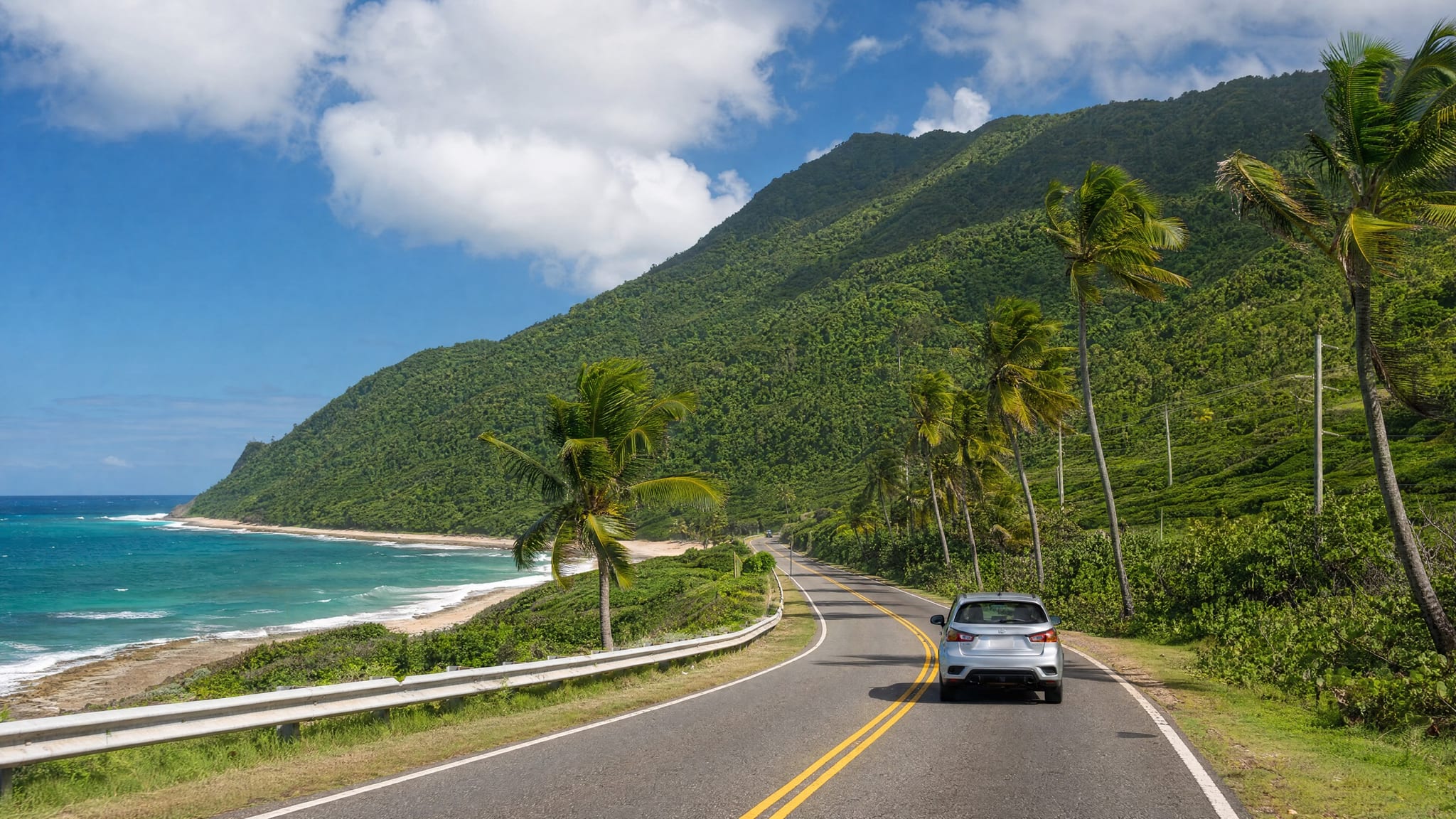 A rental car parked along a coastal road on Puerto Rico's west side